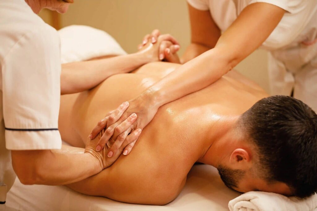Two therapists working together on a deep-tissue back massage
